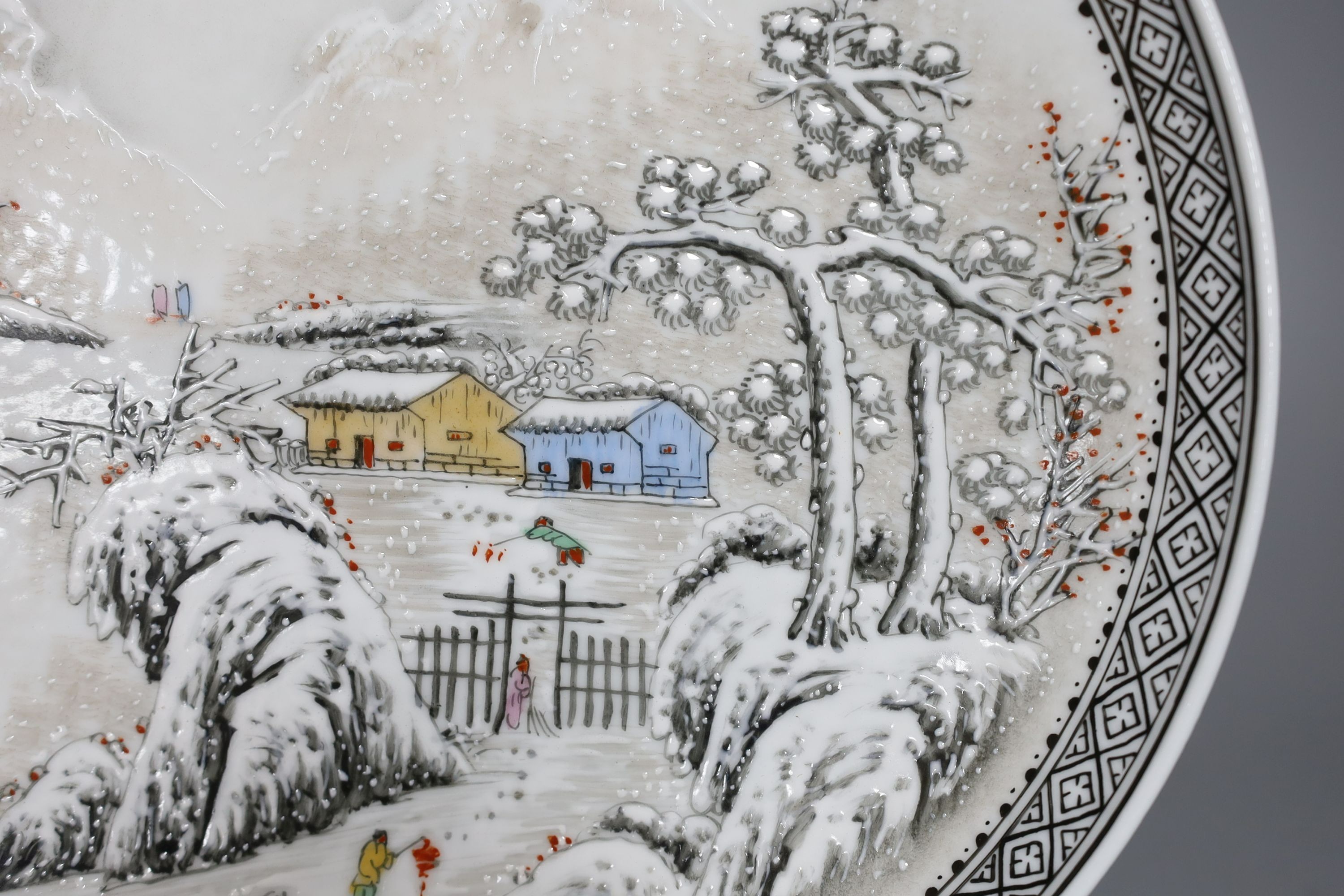 A Chinese famille rose plate depicting a winter scene - 27cm diameter